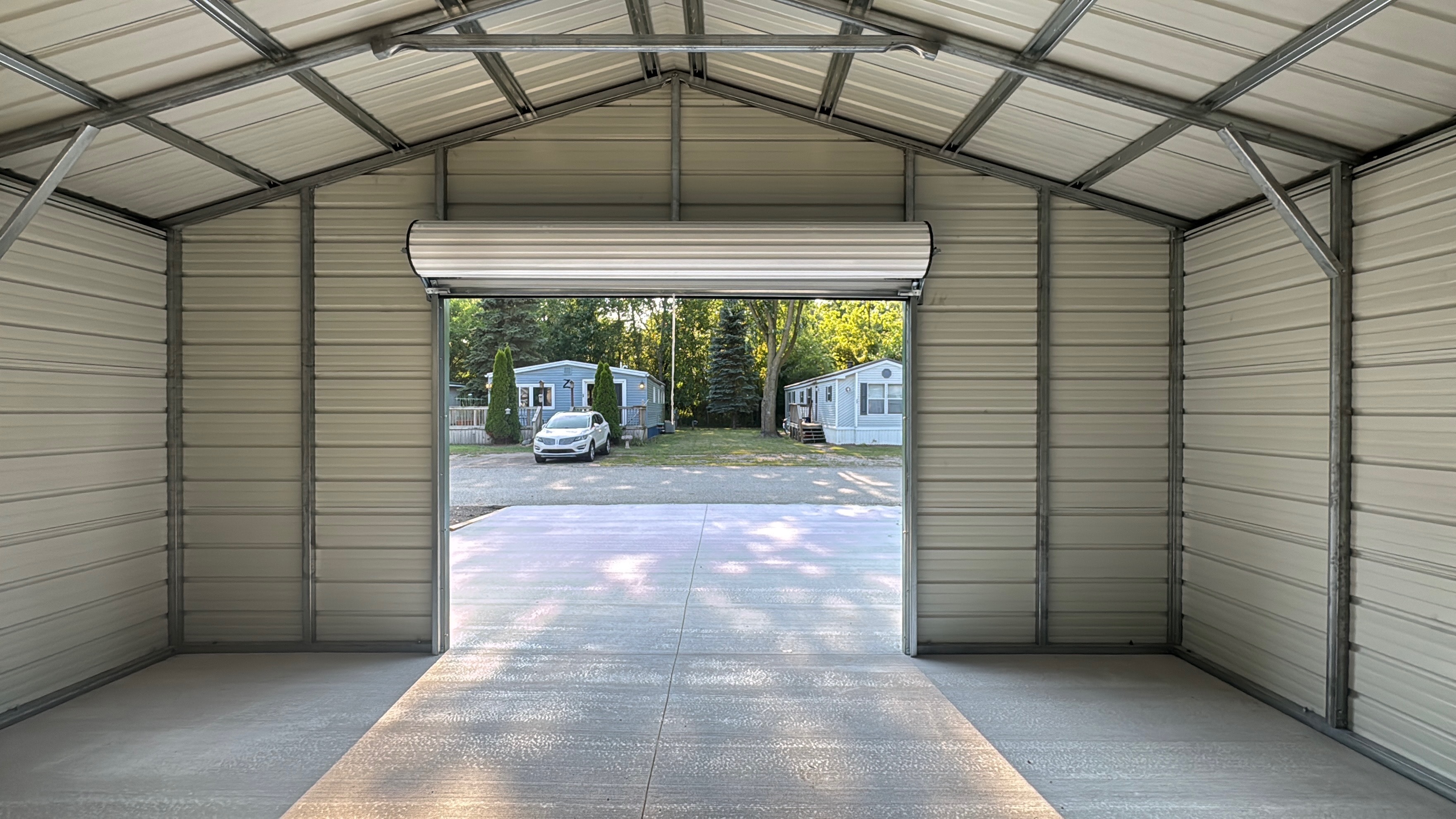 Interior view of a metal garage structure looking out through the roll-up door